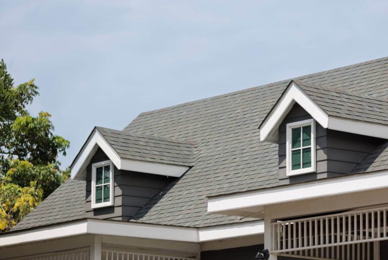 Gray shingled roof with white accent around the windows